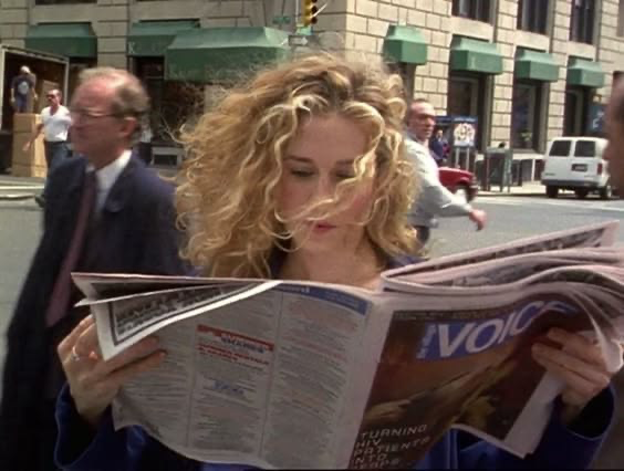 Carrie lee el periódico en una calle de Nueva York