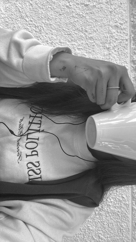 Persona con auriculares sosteniendo una taza